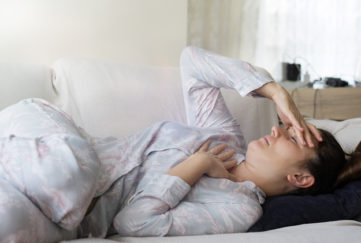 Woman in pyjamas with heartburn pain