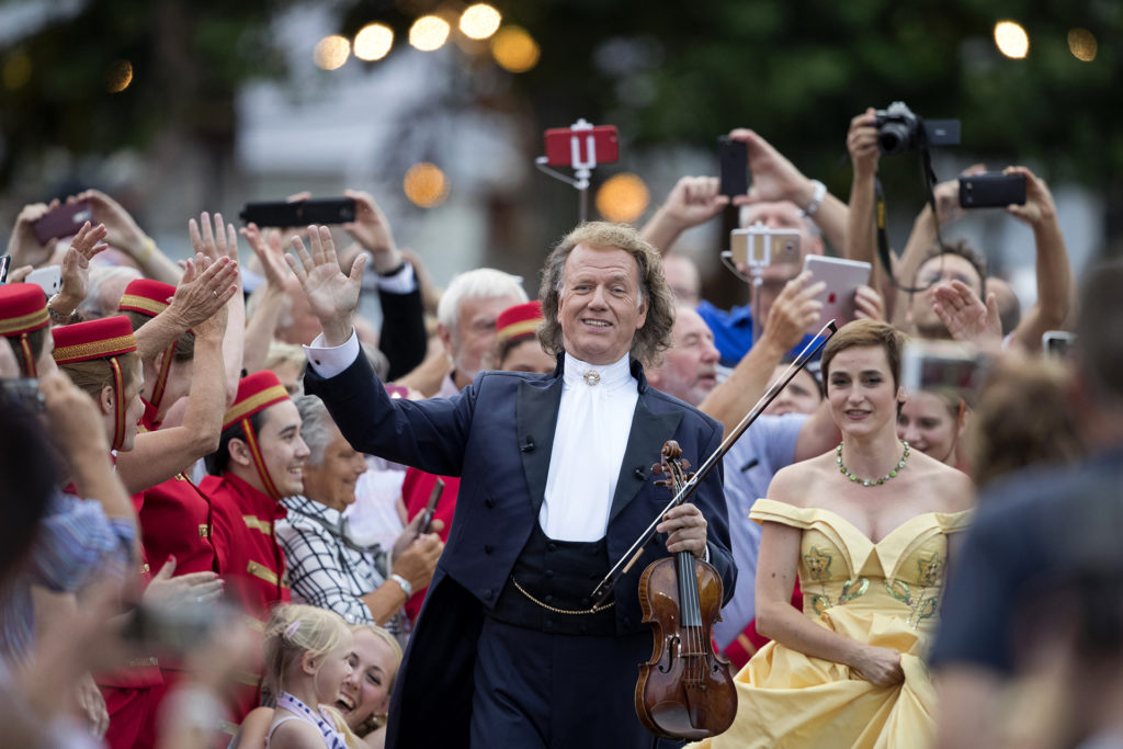 Andre Rieu surrounded by cast members of show
