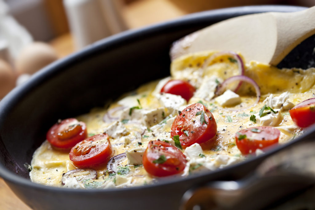 Cooking omelet in a pan, ready to serve. With Cherry tomatoes, 