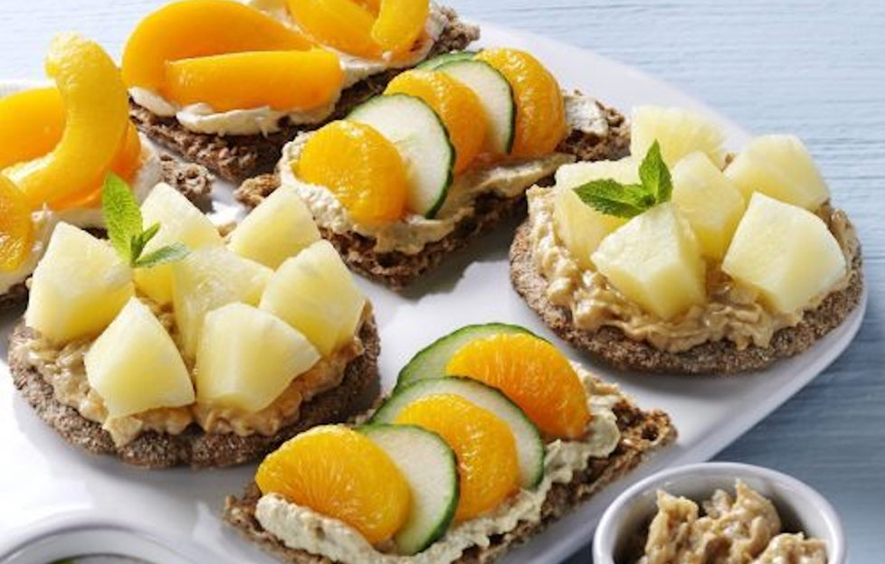 A variety of crispbread toppings with canned peach, mandarin and pineapple