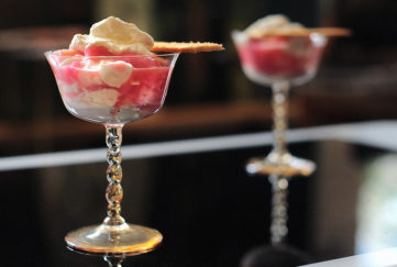 rhubarb fool in delicate stemmed glass dishes, dark background