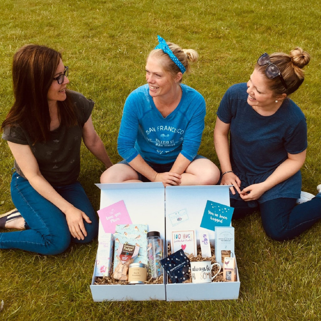 Anna Peters, Lucy Ambler, and Sophie Morris with one of the Box Of Hugs gift boxes