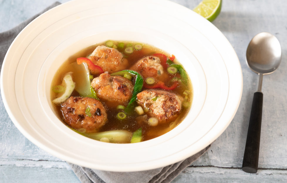 Bowl of 5 chicken meatballs in golden broth with spring onions, chilli and ginger slices