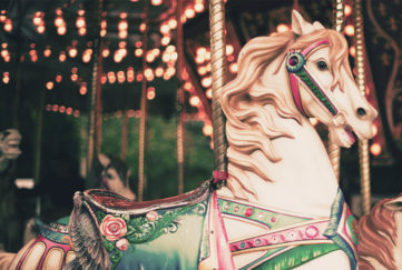 Carousel horse with green saddle, decorated with roses