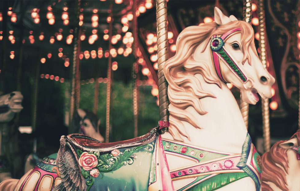 Carousel horse with green saddle, decorated with roses