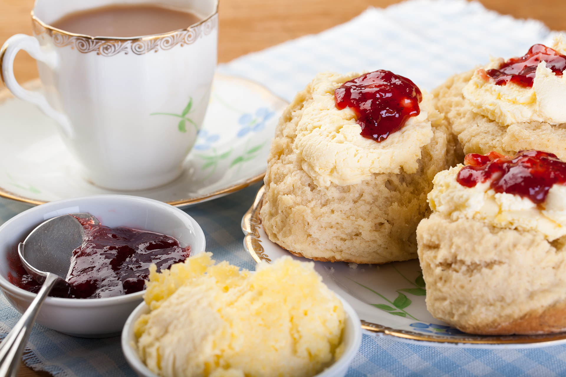 "Traditional scones, cream and jam served with a cup of tea"