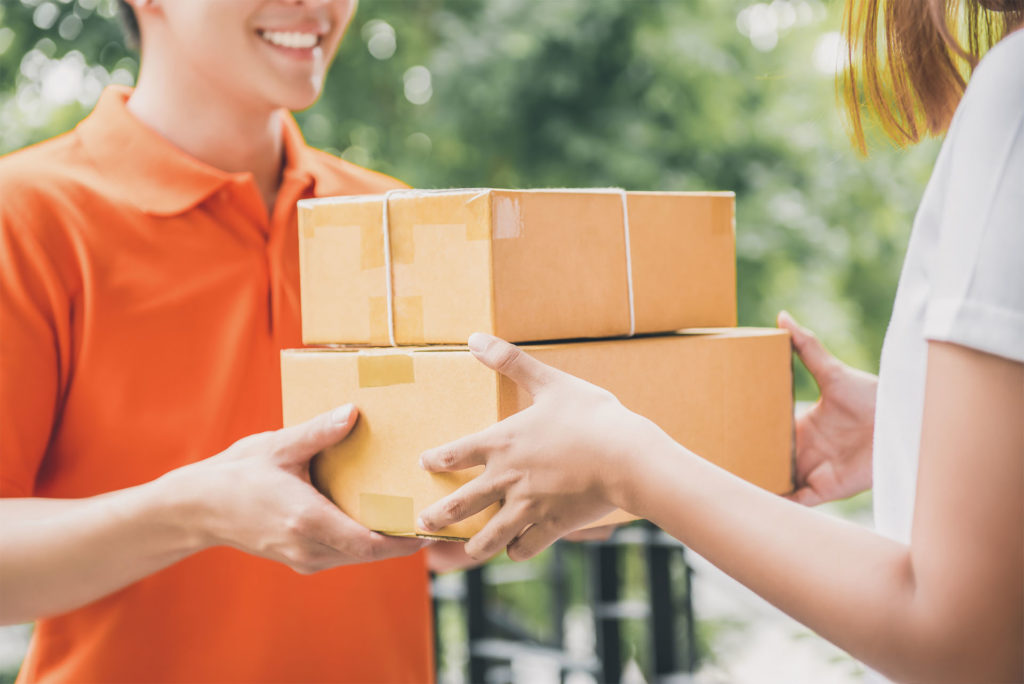 Man delivers two parcels to a woman at the door