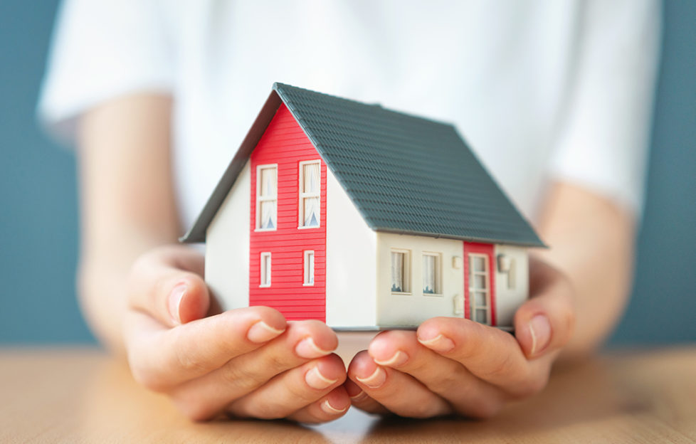 Lady holding a model house in her hands Pic: Istockphoto