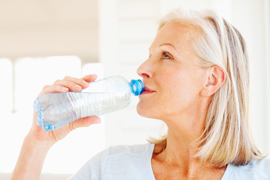 Senior woman drinking from a water bottle