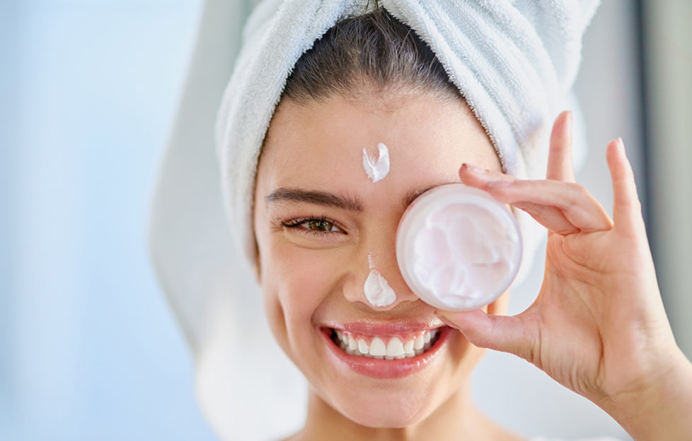 Woman with moisturiser packaging covering her eye Pic: Istockphoto