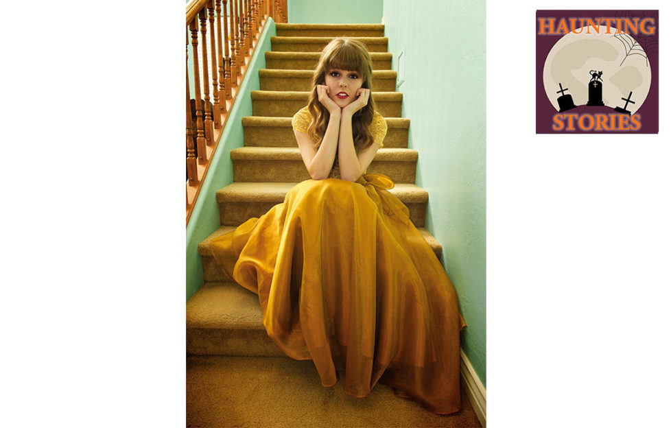 Young woman in mustard coloured floaty dress sits at the bottom of a flight of stairs, chin in hands, looking alarmed, scared of lightning