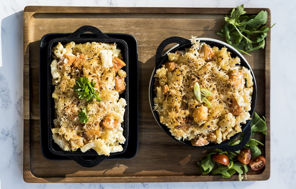 Two dishes of macaroni with cubes of pumpkin, topped with breadcrumbs and cheese