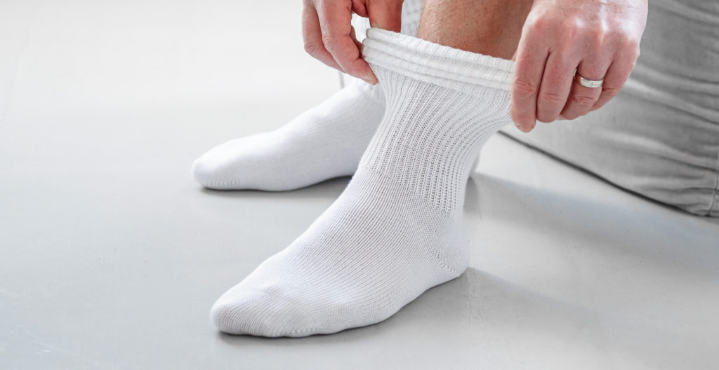 Hands pulling on white socks