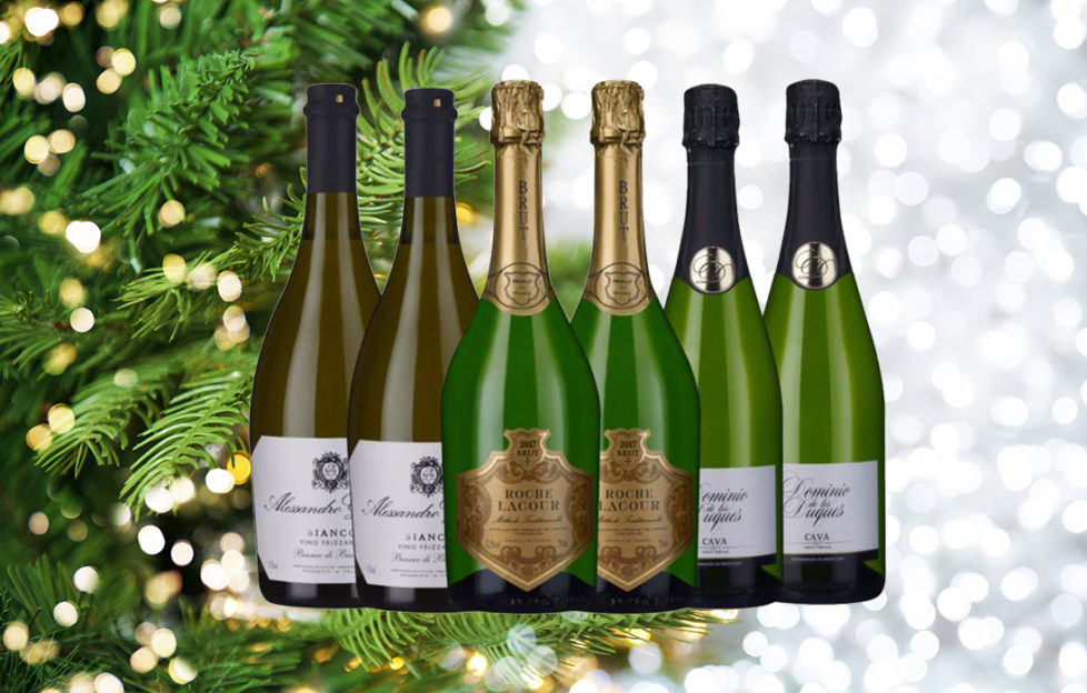 6 bottles of sparkling wine with Christmas tree in background Background pic: Istockphoto