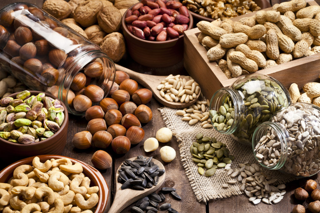 Assortment of nuts on rustic wood table.