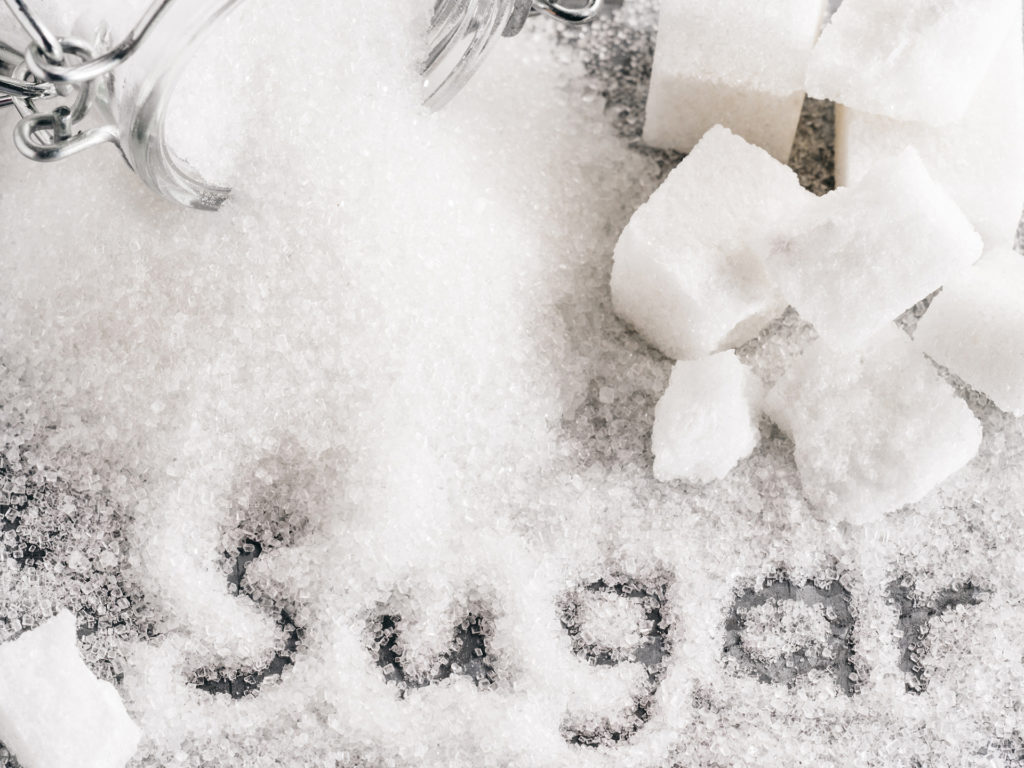 Close up view of word sugar of granulated sugar. sugar cubes. Top view or flat lay.