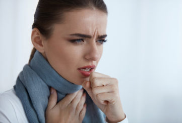 Woman with scarf coughing painfully