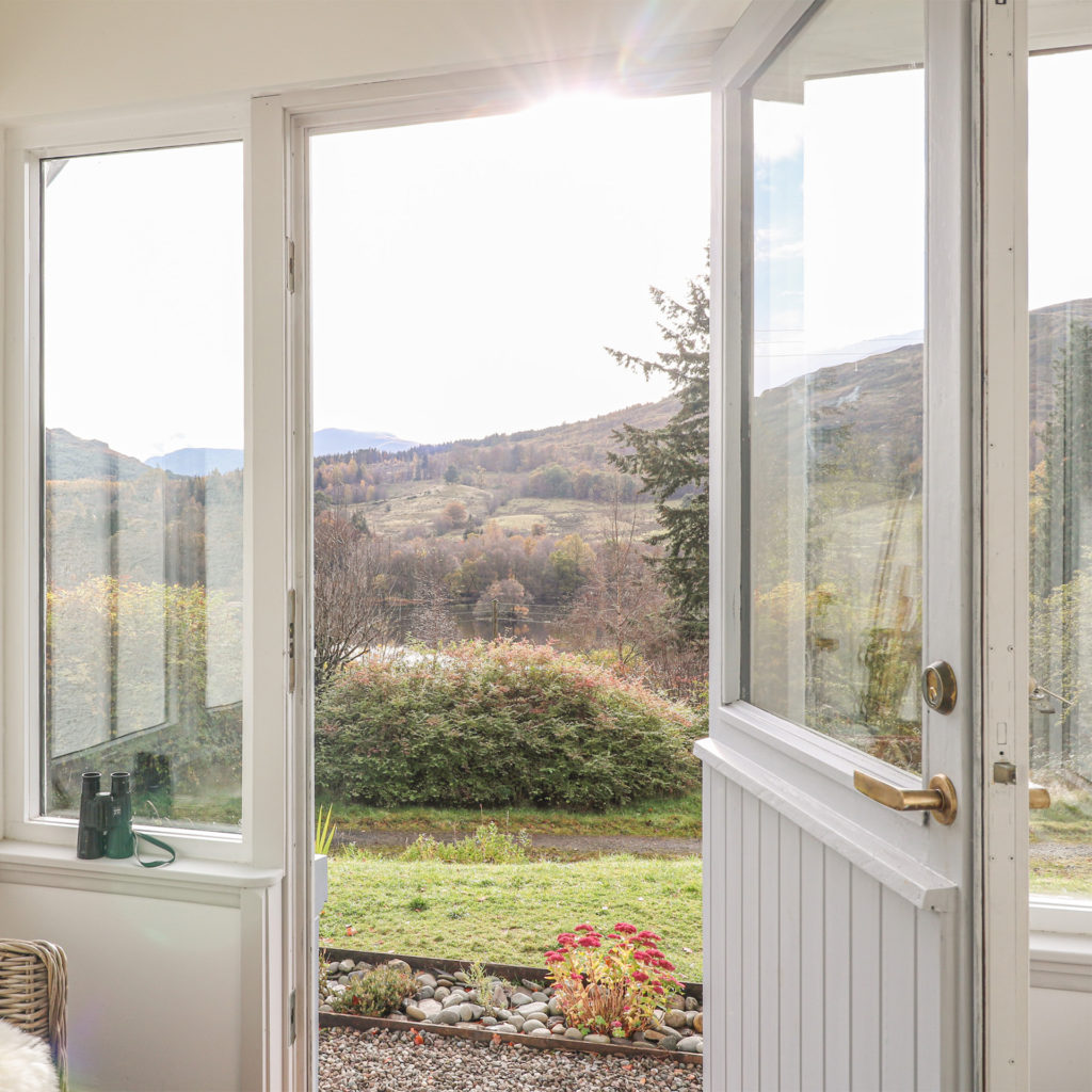 Open porch door looking out onto heather clad hillside