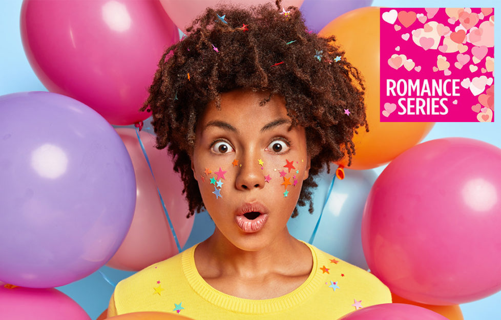 Young mixed race woman looking shocked and scared, surrounded by bright coloured balloons