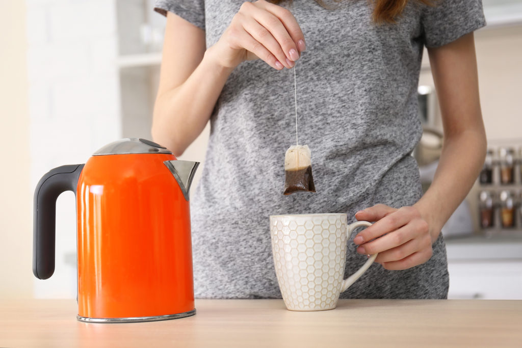 Woman making cup of tea with teabag