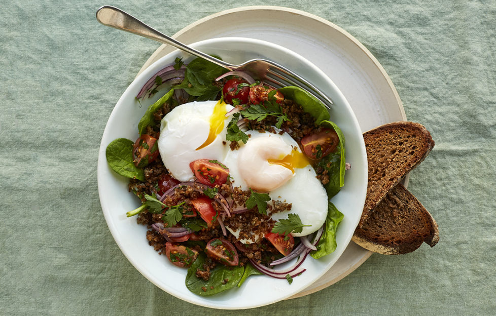 Poached eggs on top of bowl of salad