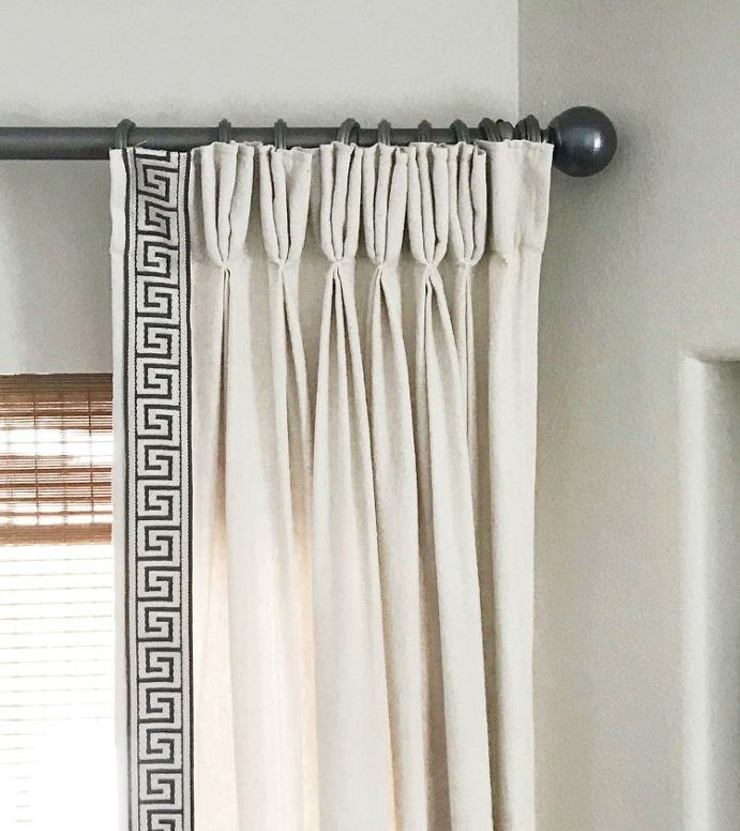 Cream curtains with decorative pleats and Greek key tape edging, on pewter effect pole with ball finial at end