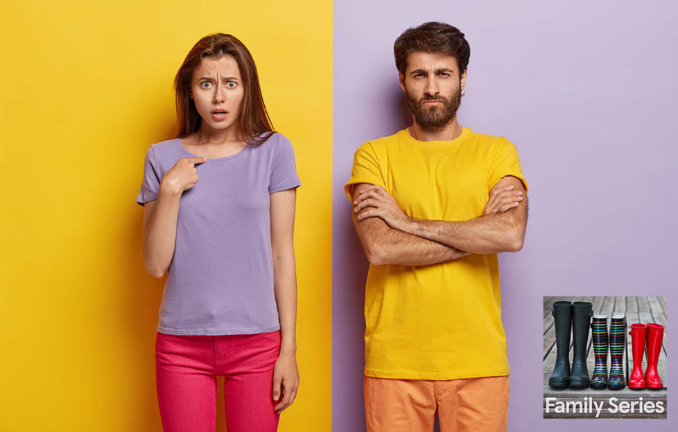 Girl in purple t shirt against yellow wall, man in yellow t shirt against purple wall. He looks defensive, she is asking, "what, me?"