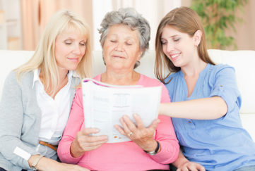Three women looking at magazine Pic: Istockphoto
