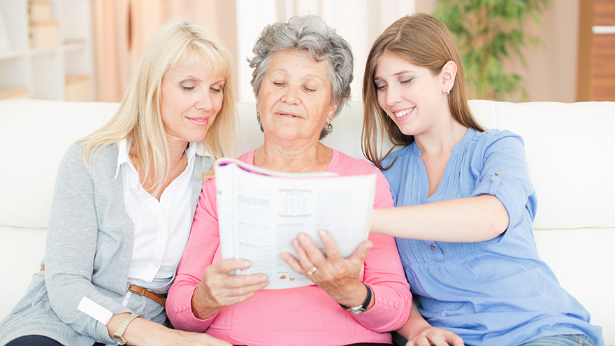 Three women looking at magazine Pic: Istockphoto