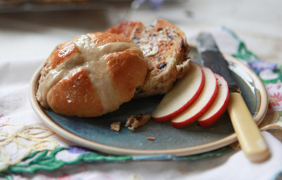 Toasted hot cross buns with butter and slices of Pink Lady apples