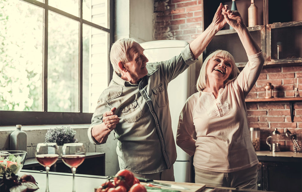 Mature couple dancing in kitchen, happy relationship