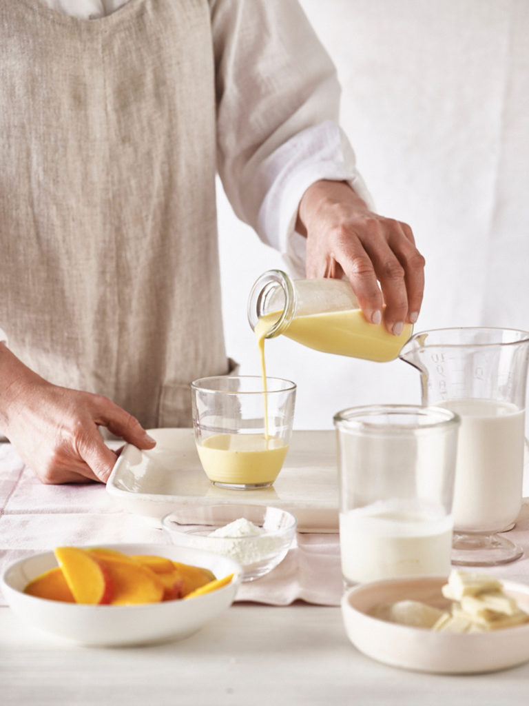 Man pouring milkshake in a glass at breakfast