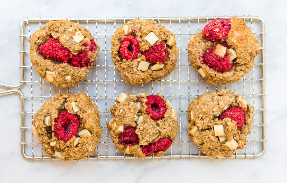 6 cookies on a wire tray, studded with raspberries and white choc chunks