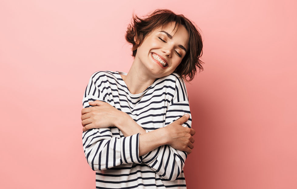 Happy lady giving herself a hug Pic: Shutterstock