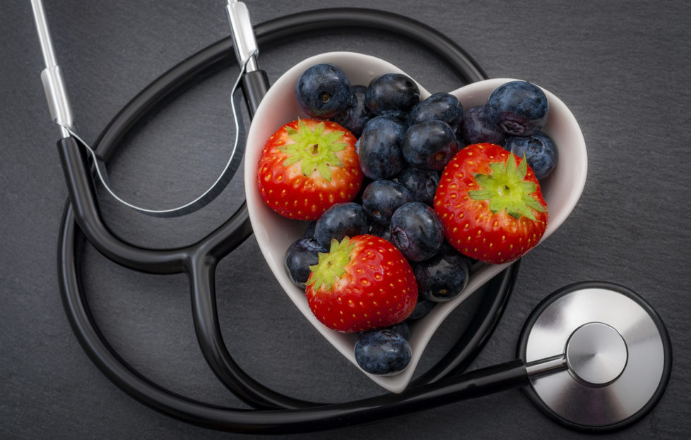 Healthy eating and heart health concept with a heart shaped bowl with blueberries and a stethoscope each blueberry is packed full of vitamins and antioxidants that can prevent coronary heart disease;