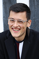 Portrait of smiling dark-haired young man in clear plastic-framed glasses