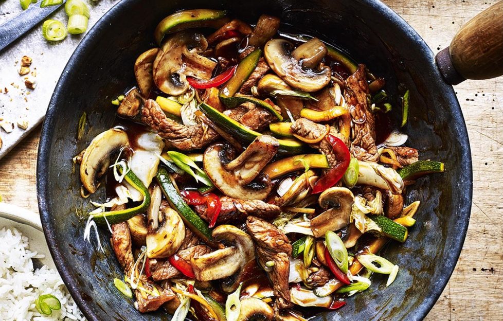 Mushroom and beef stir fry in a wok with multi-coloured vegetables