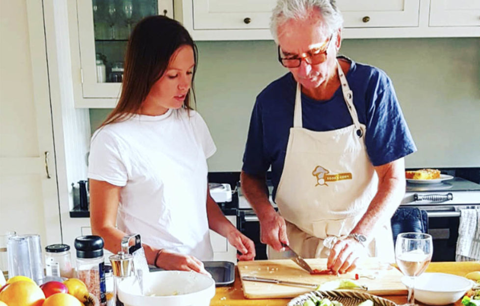 Woman and elderly man working at a kitchen worktop