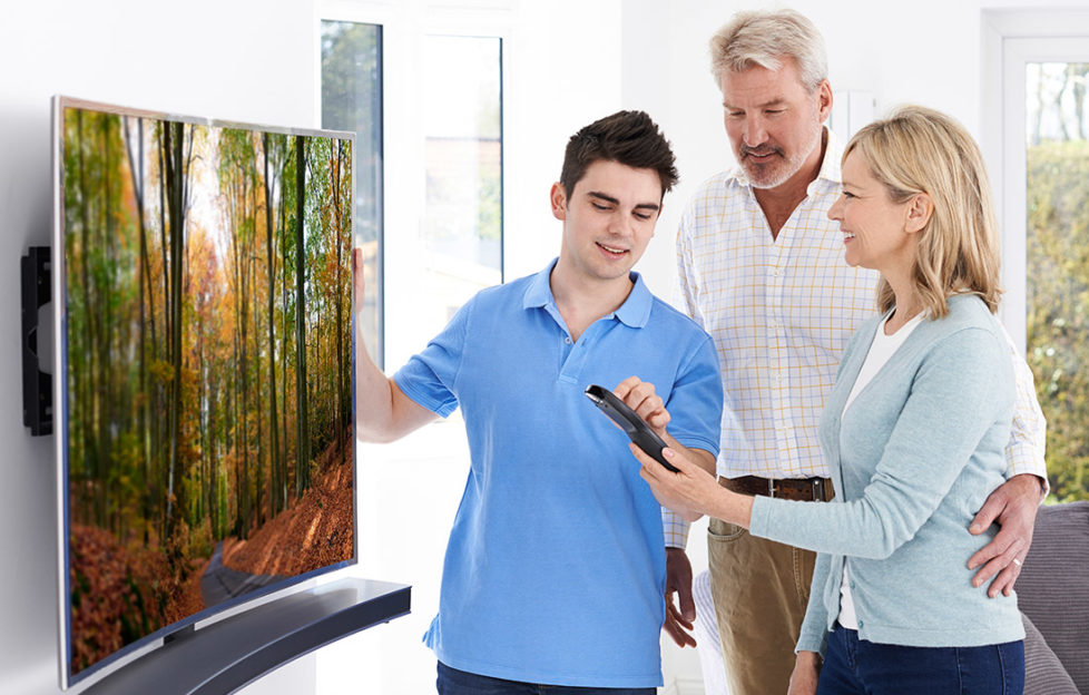 Buy laUse a credit card for large purchases. Man Demonstrating New Television To Mature Couple At Home