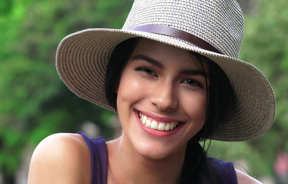 Woman wearing a straw hat in green garden