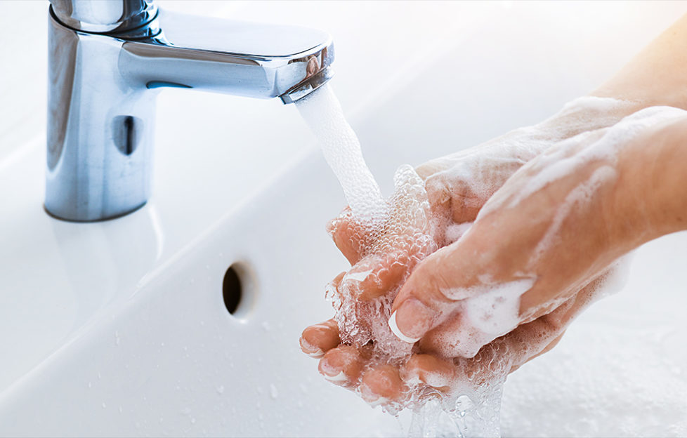 Woman use soap and washing hands under the water tap. Hygiene concept hand detail.