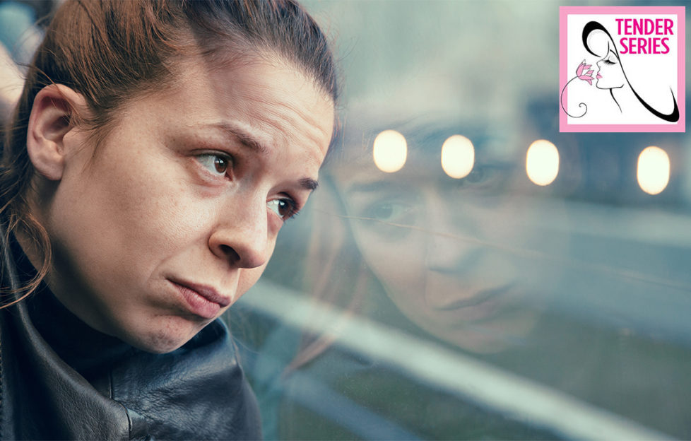 Worried woman looks out of bus window at grey rainy landscape and reflected lights