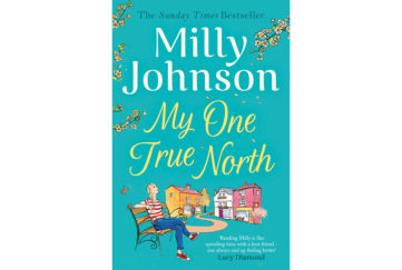 cover of my one true north, happy young woman sitting on bench in village