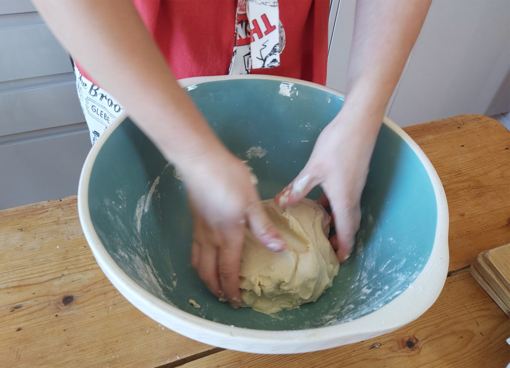 Hands in mixing bowl, kneading dough