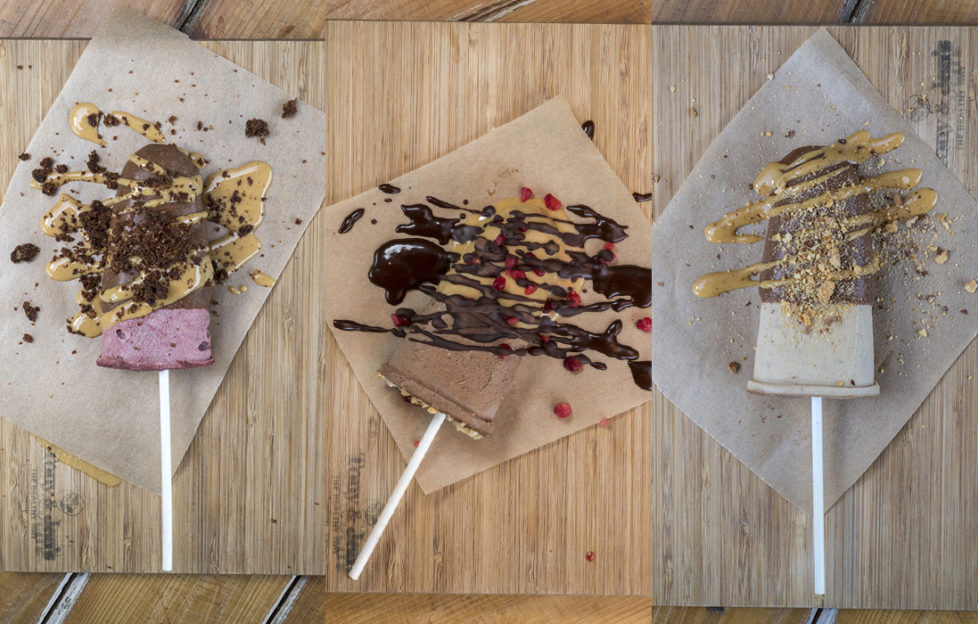3 home made choc ice lollies on greaseproof paper with sauce drizzled and crushed nuts sprinkled on. 3 different recipes