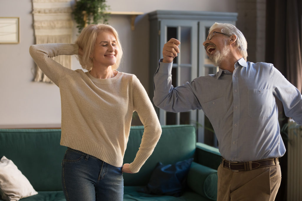 Elderly couple dancing in living room
