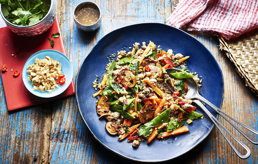 Blue plate with colourful mix of golden mushrooms, green coriander, cherry tomatoes, orange papaya and fried minced chicken