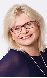 Smiling blonde woman in glasses and plain dark blue top