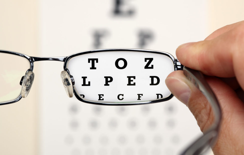 Looking through glasses at an eye exam chart;