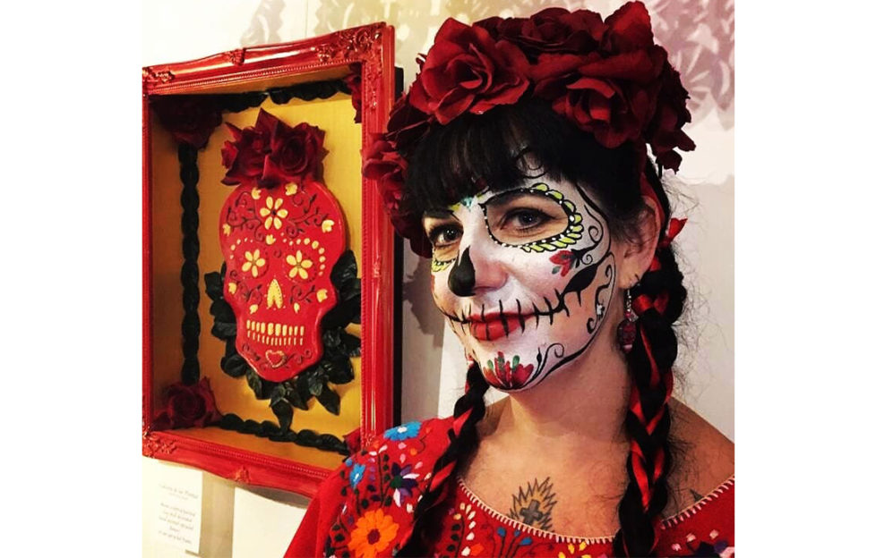 Dia de los muertos. Woman with crown of roses and skull facepaint with colourful artwork of a skull